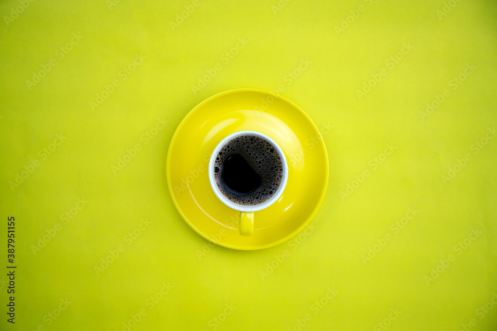 Colorful coffee cup on yellow paper background.