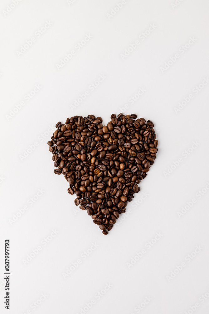 Coffee beans in shape of heart on white background, flat lay