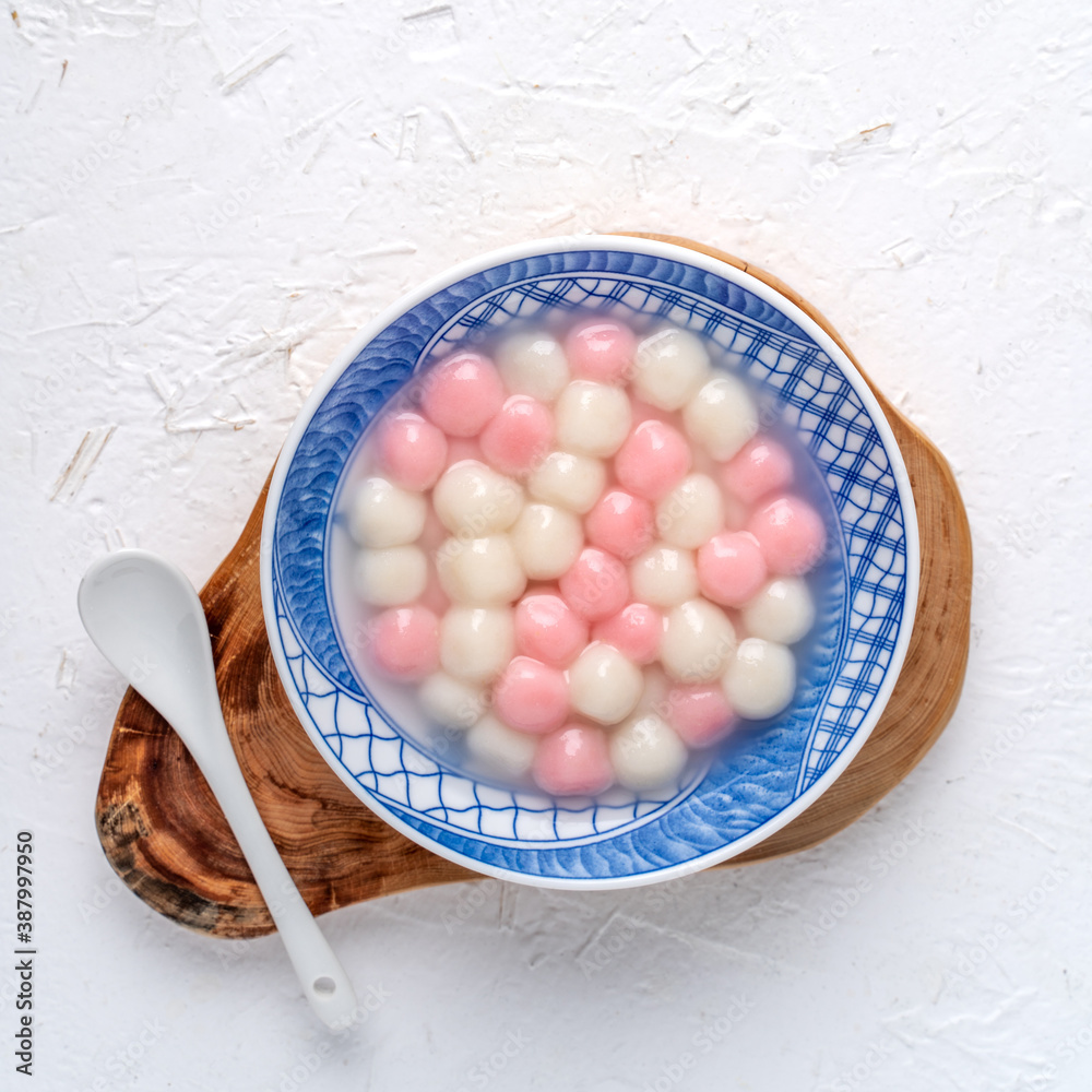 Top view of red and white tangyuan in blue bowl on white background for Winter solstice.