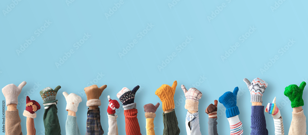 Hands up up in the different mittens. Winter concept.	
