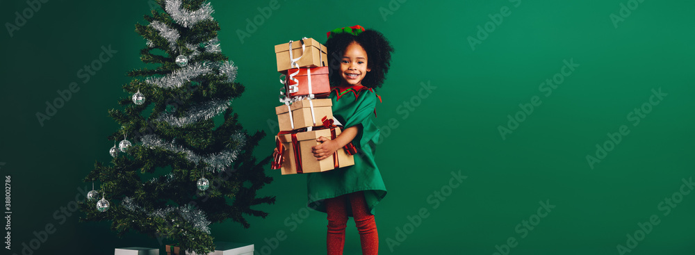 Smiling kid holding a pile of gift boxes