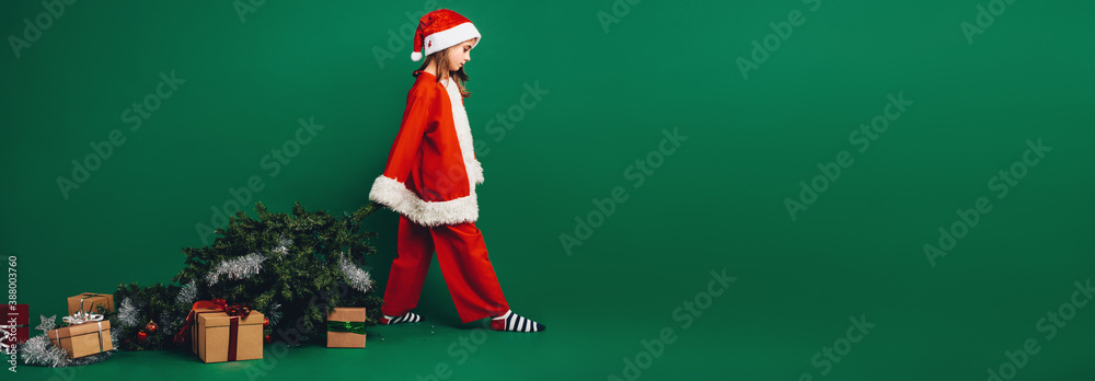 Little girl santa on green backgound.