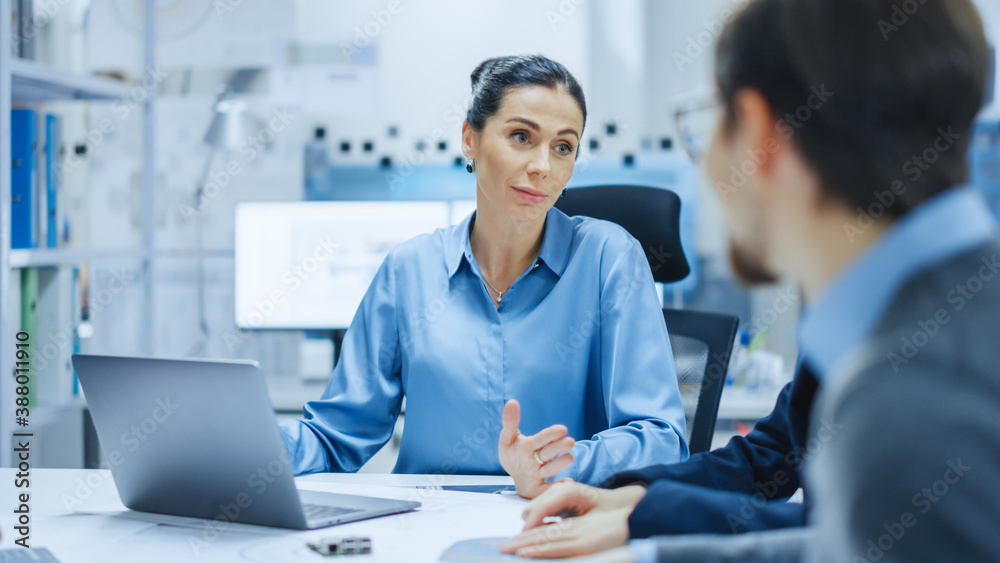 Modern Factory Office Meeting Room: Confident Female Project Manager Talks to Diverse Team of Engine