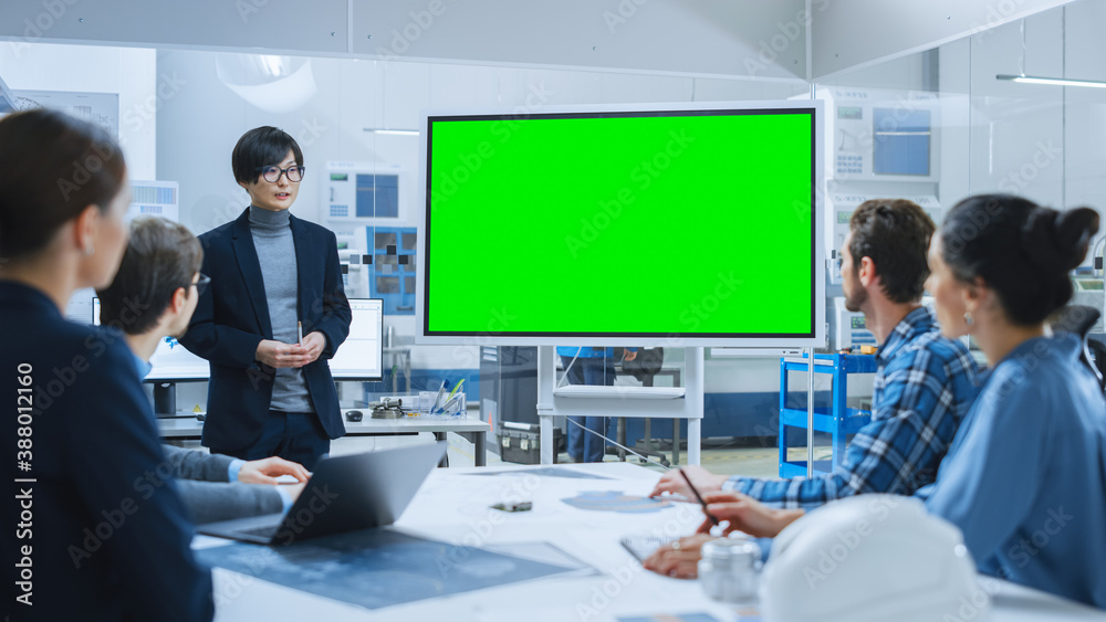 Modern Industrial Factory Meeting: Confident Asian Engineer Uses Interactive Green Mock-up Screen Wh