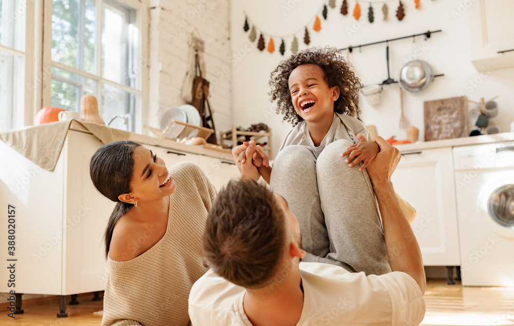 Happy multiracial family playing in kitchen.