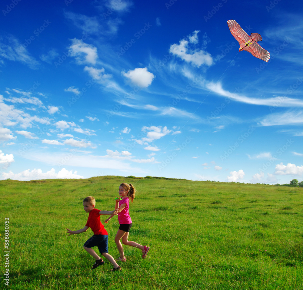  boy and girl run with kite in the field