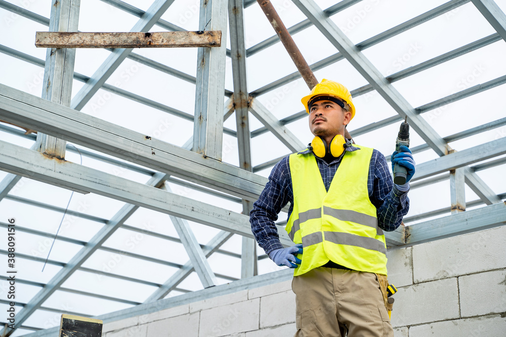 Construction worker using an electric pneumatic drill bricks and build interior walls,Professional o