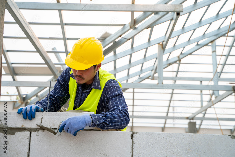 Construction worker builds a brick wall in the new house.