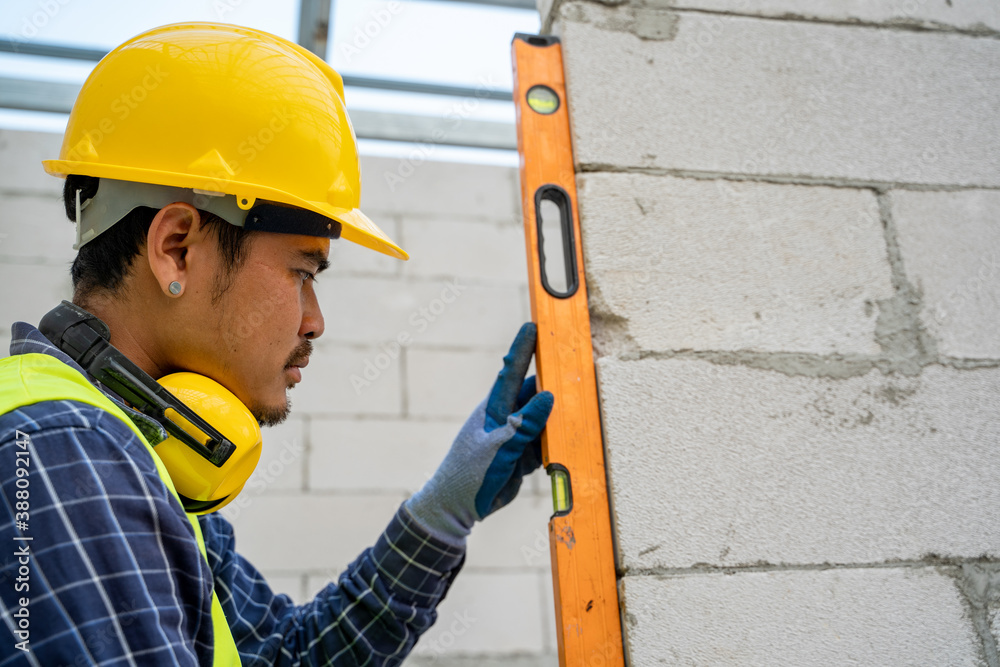 Masonry worker make concrete,Level is used when laying bricks in order to check verticality,Smooth b