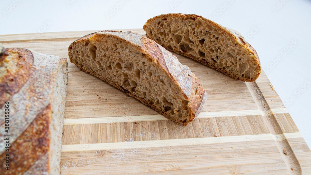 Pieces of homemade whole grain rye bread on a wooden board (on the object on the left the focus is s