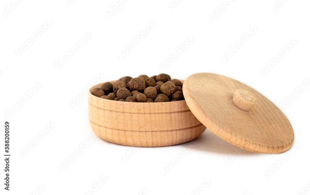 a dried aromatic allspice pepper fruit in wooden bowl isolated on white background, the concept of k