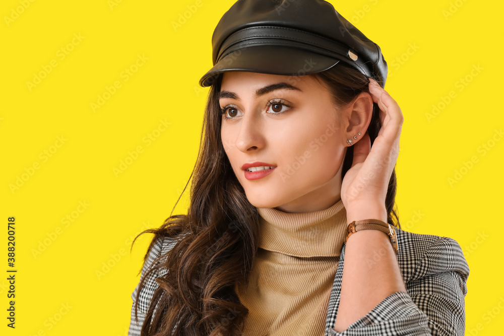 Stylish young woman in autumn clothes on color background