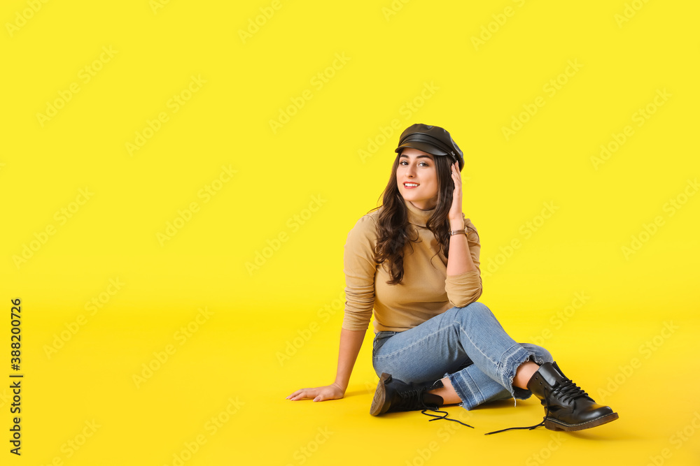 Stylish young woman in autumn clothes on color background