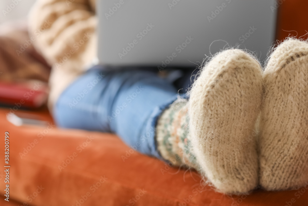 Legs of young woman in warm socks at home