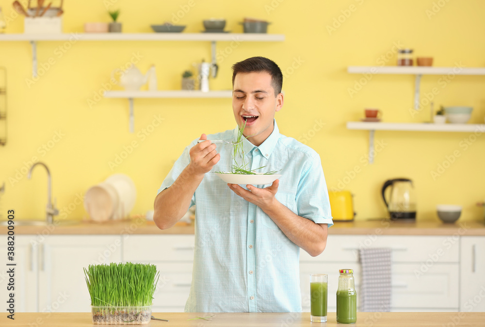 Young man eating wheatgrass at home