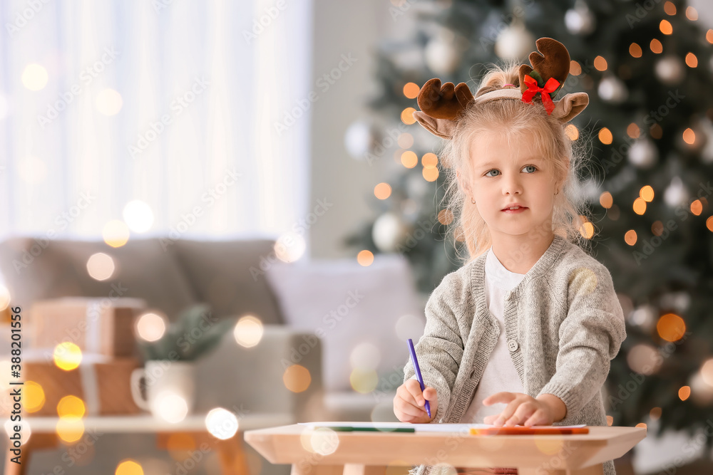 Cute little girl writing letter to Santa at home