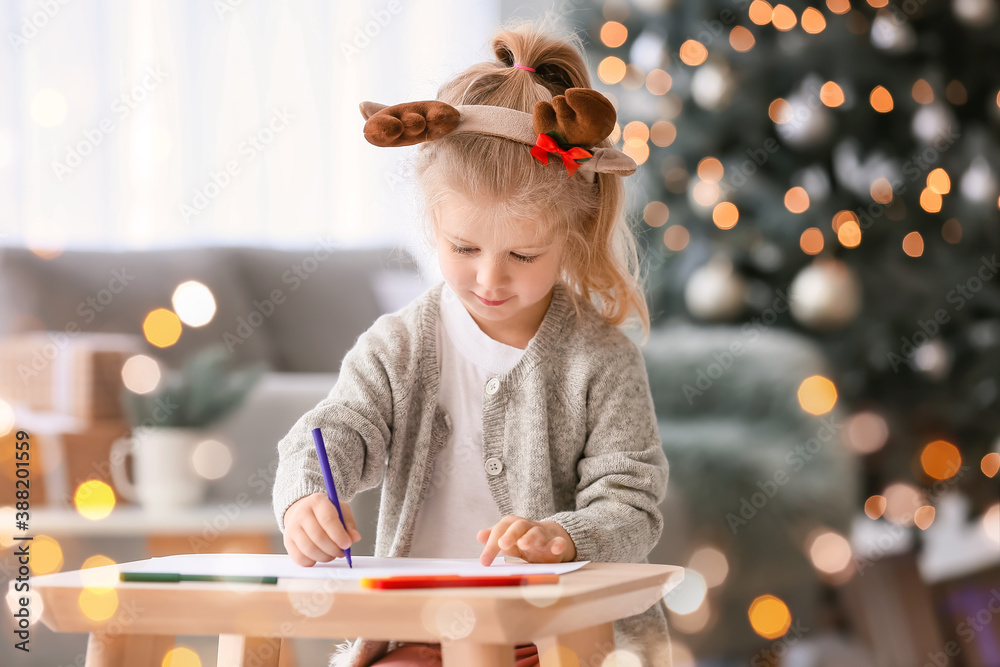 Cute little girl writing letter to Santa at home