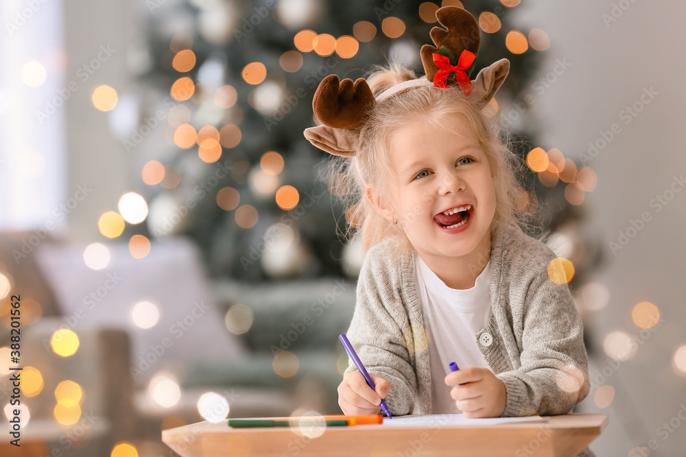 Cute little girl writing letter to Santa at home