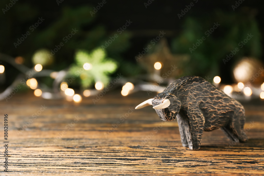 Figurine of bull as symbol of year 2021 on wooden table