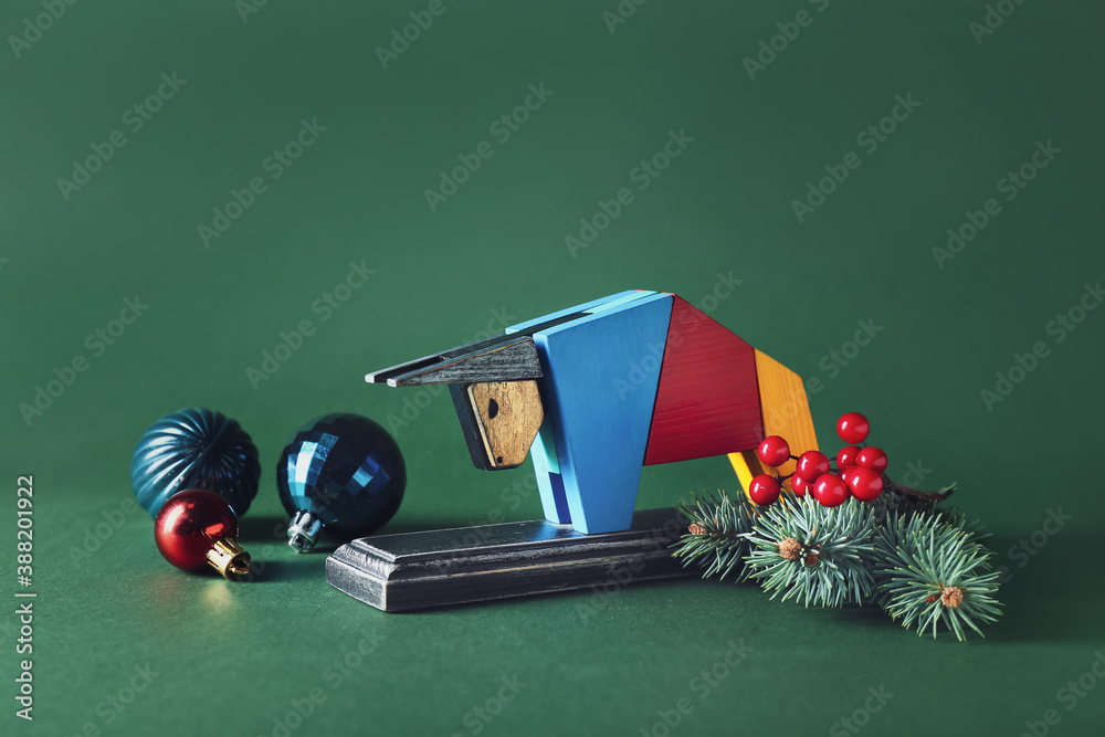 Figurine of bull and New Year decor on color background