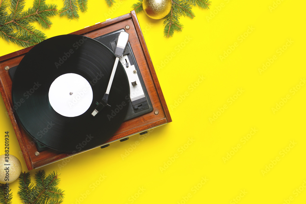 Record player and Christmas decor on color background