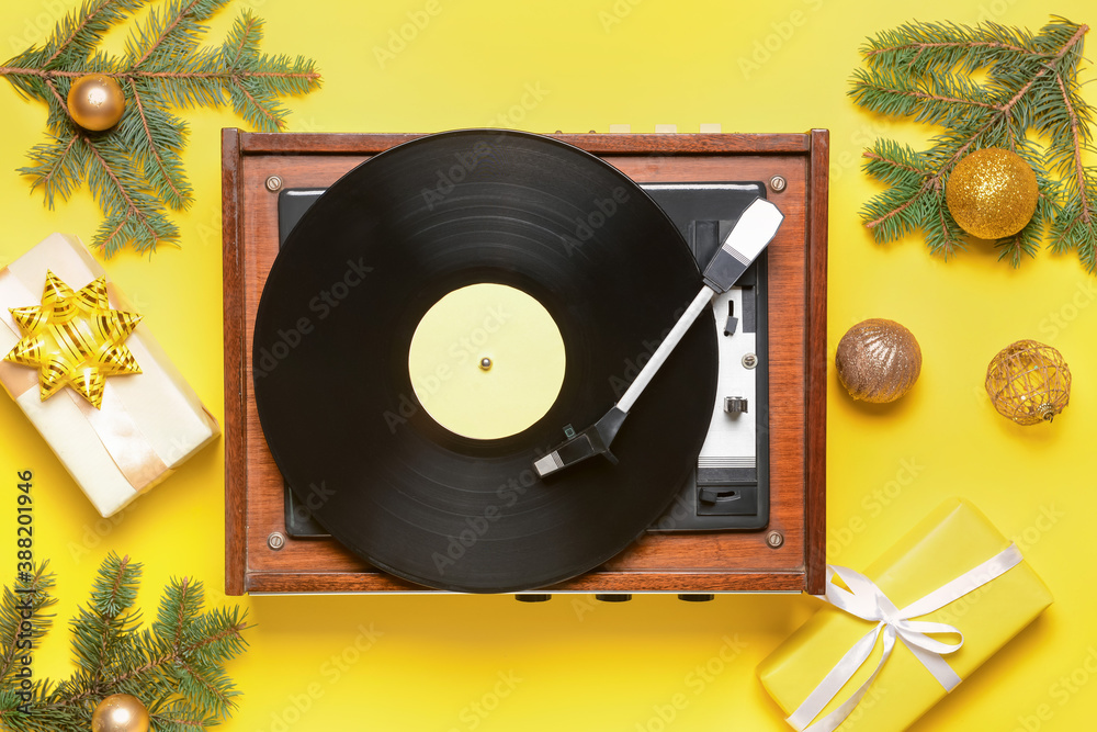 Record player and Christmas decor on color background