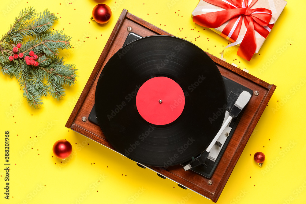 Record player and Christmas decor on color background