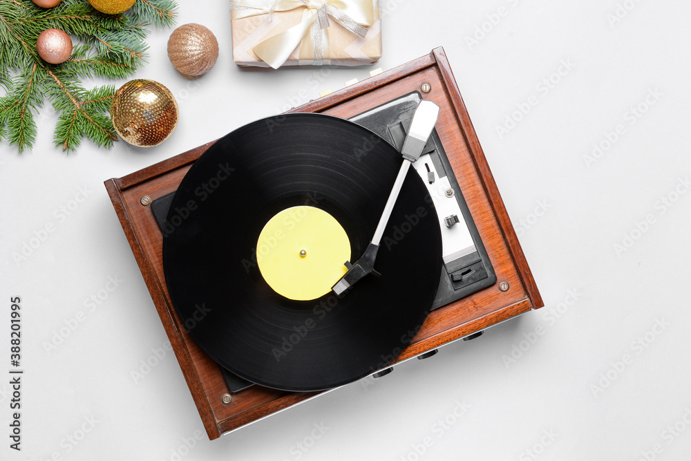 Record player and Christmas decor on light background