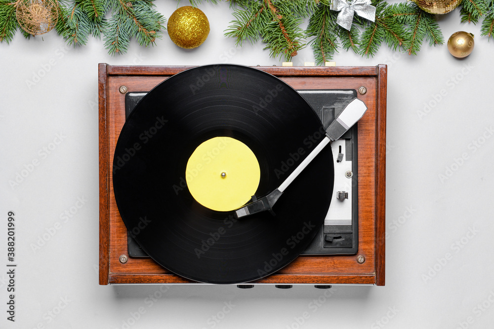 Record player and Christmas decor on light background