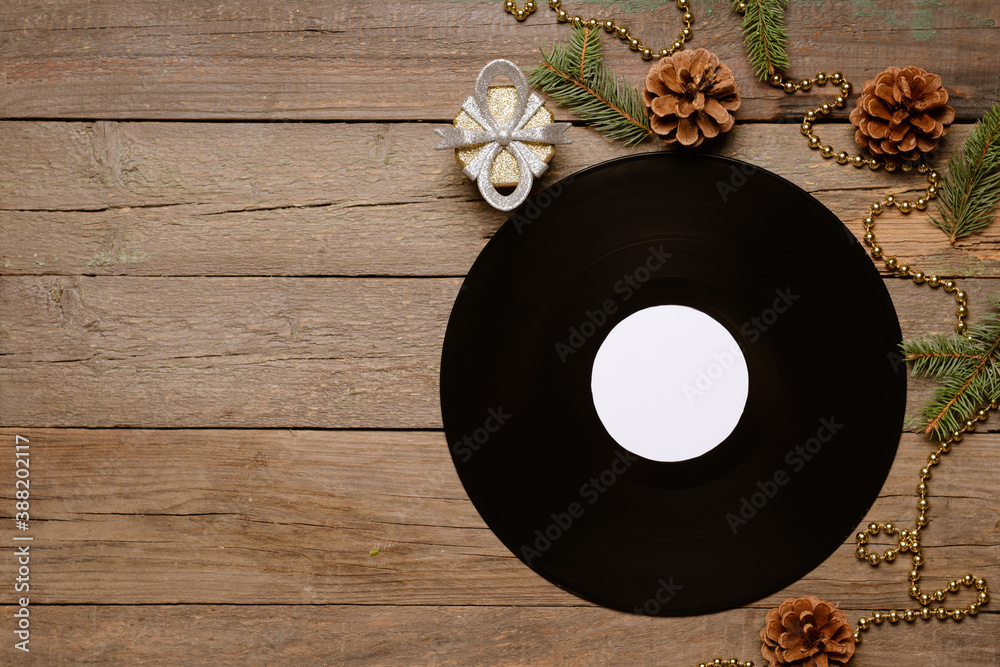 Vinyl disk and Christmas decor on wooden background