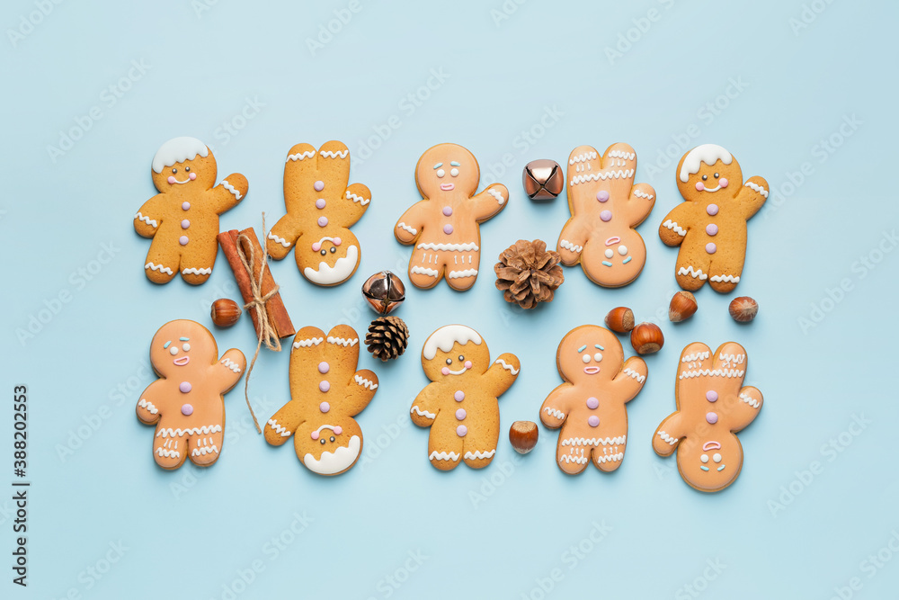 Tasty gingerbread cookies and Christmas decor on color background