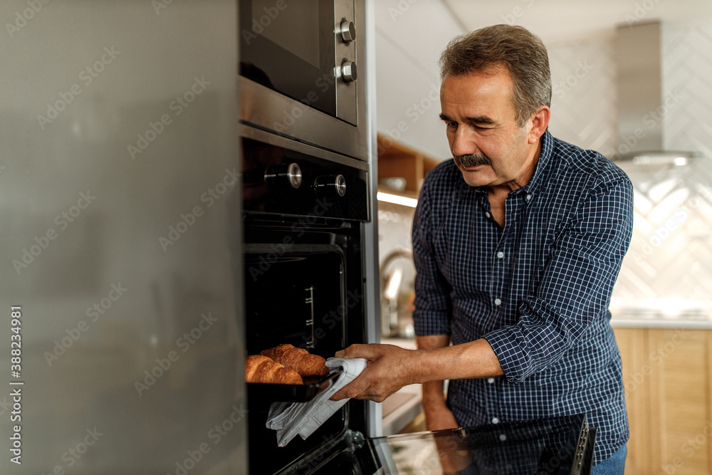 Baking croissants in his oven.