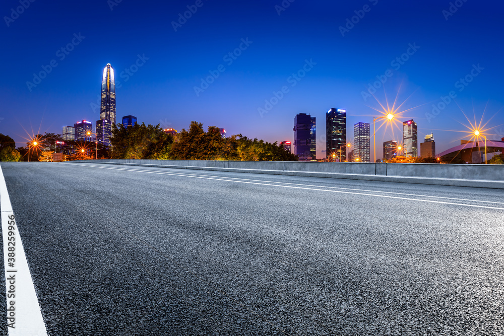 Asphalt highway and urban commercial building scenery in Shenzhen at night.