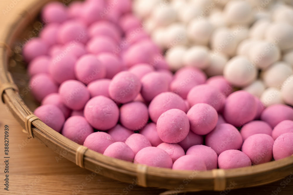 Raw little tangyuan in a sieve over wooden table.