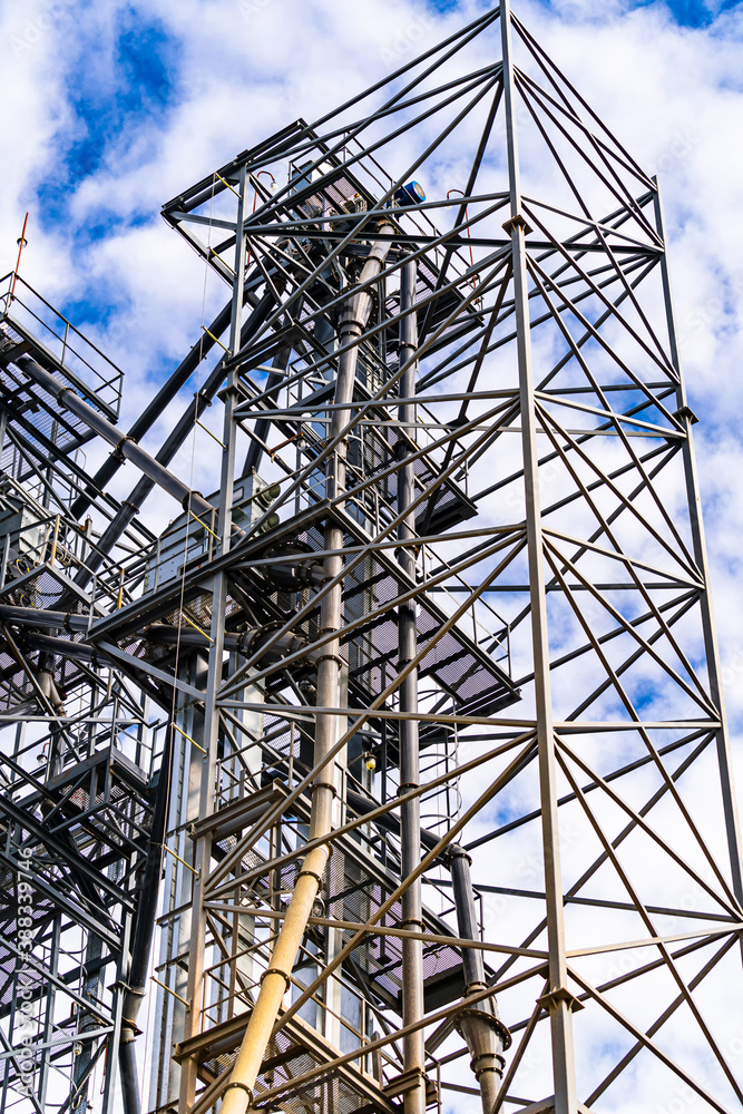 Wireframe in the plant. Steel construction near grain elevators. Selective focus from below.