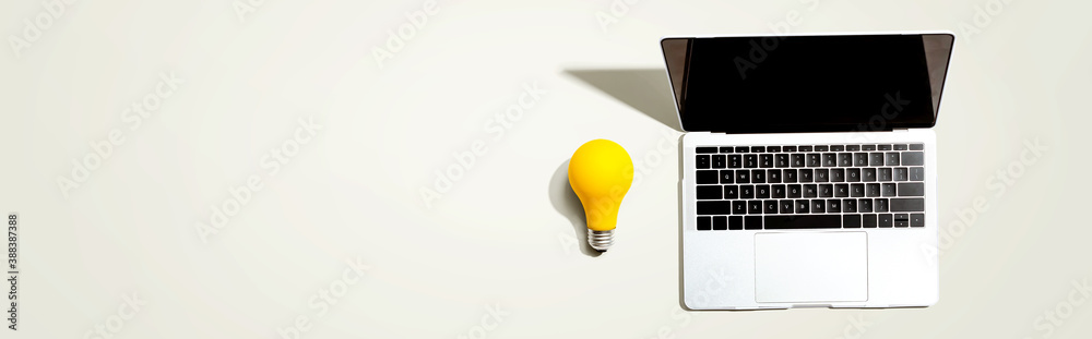 Laptop computer with a yellow light bulb from above