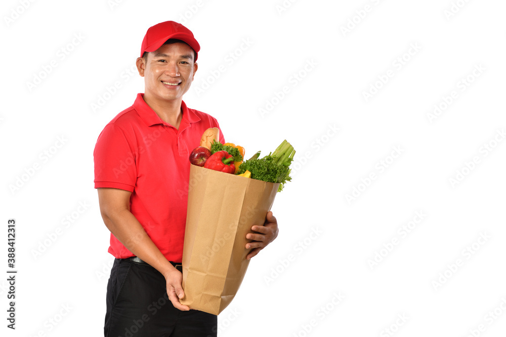 Asian delivery man in red uniform carry grocery bag in hands isolated on white background