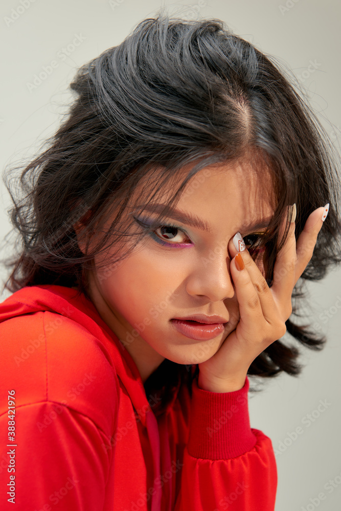 Young female model with colorful makeup. Face closeup portrait photo of teenager.