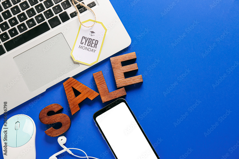 Laptop with mobile phone and word SALE on color background