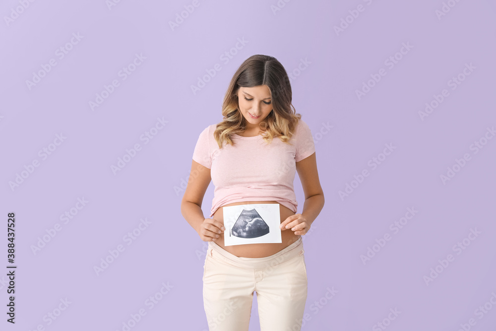 Beautiful pregnant woman with sonogram image on color background