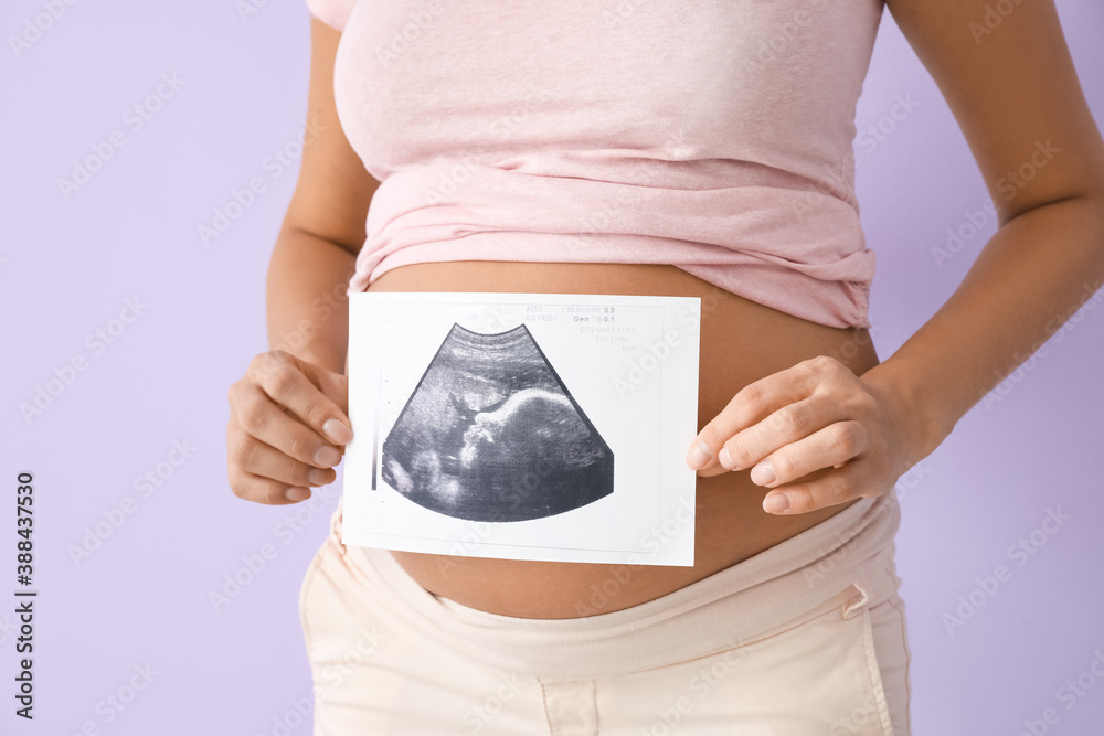 Beautiful pregnant woman with sonogram image on color background, closeup