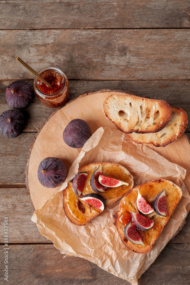 Tasty sandwiches with sweet fig jam on table