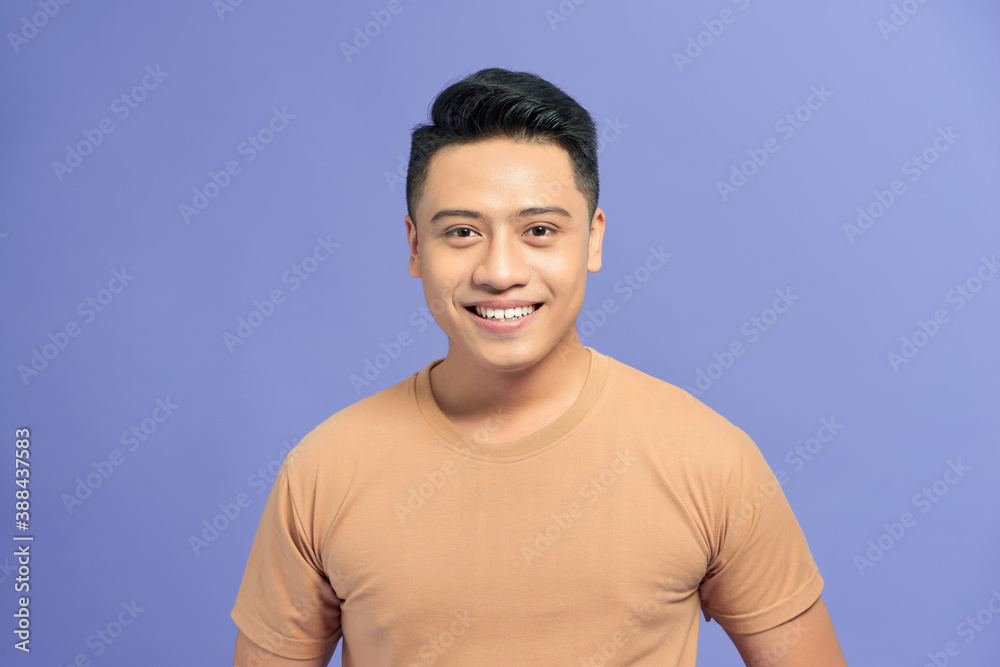 Happy young man. Portrait of handsome young man smiling while standing against color background