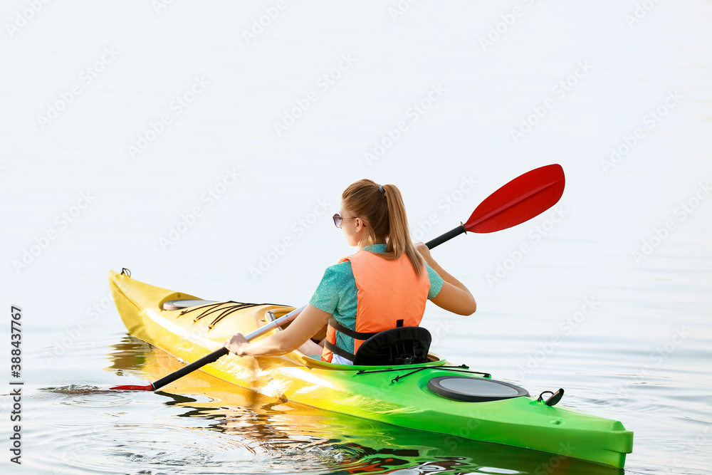 Young woman kayaking in river