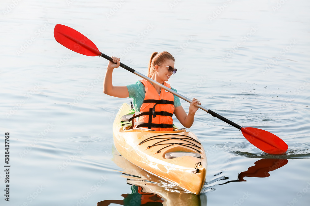 Young woman kayaking in river