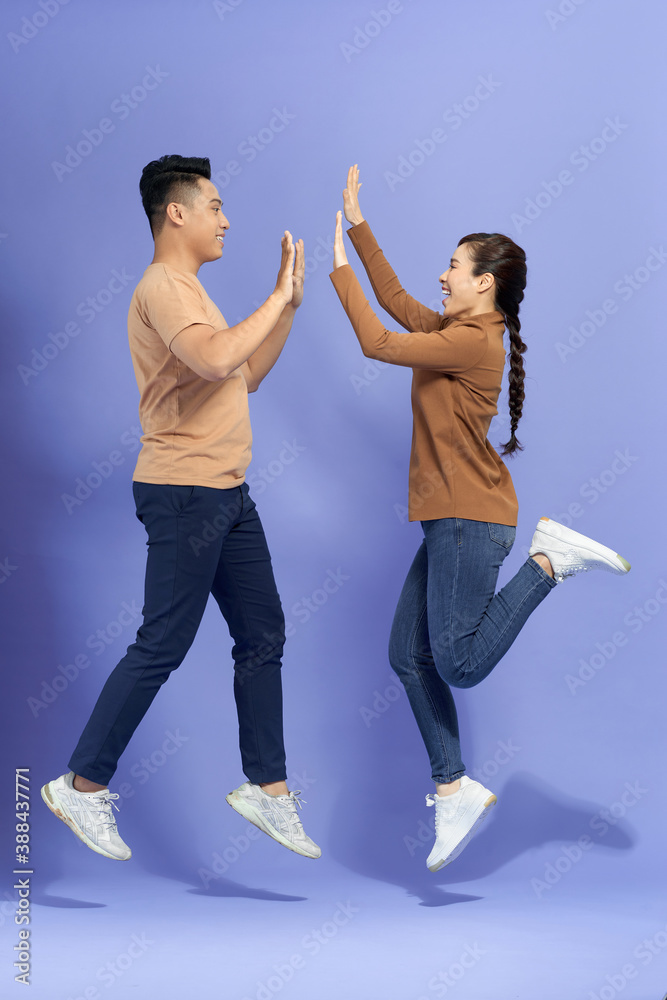 Young Man with Woman Jumping and Giving High Five