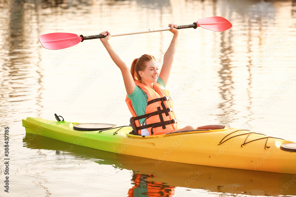 Young woman kayaking in river