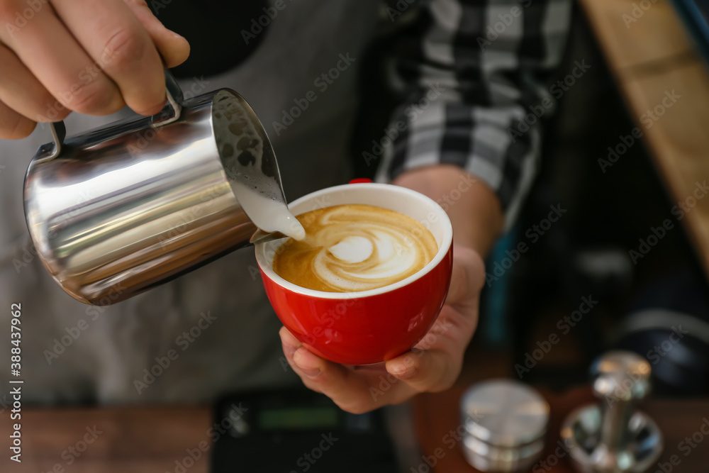 Barista making hot coffee in cafe, closeup