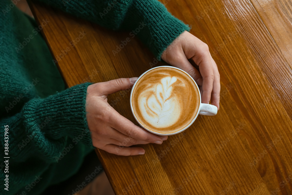 Woman drinking hot coffee in cafe