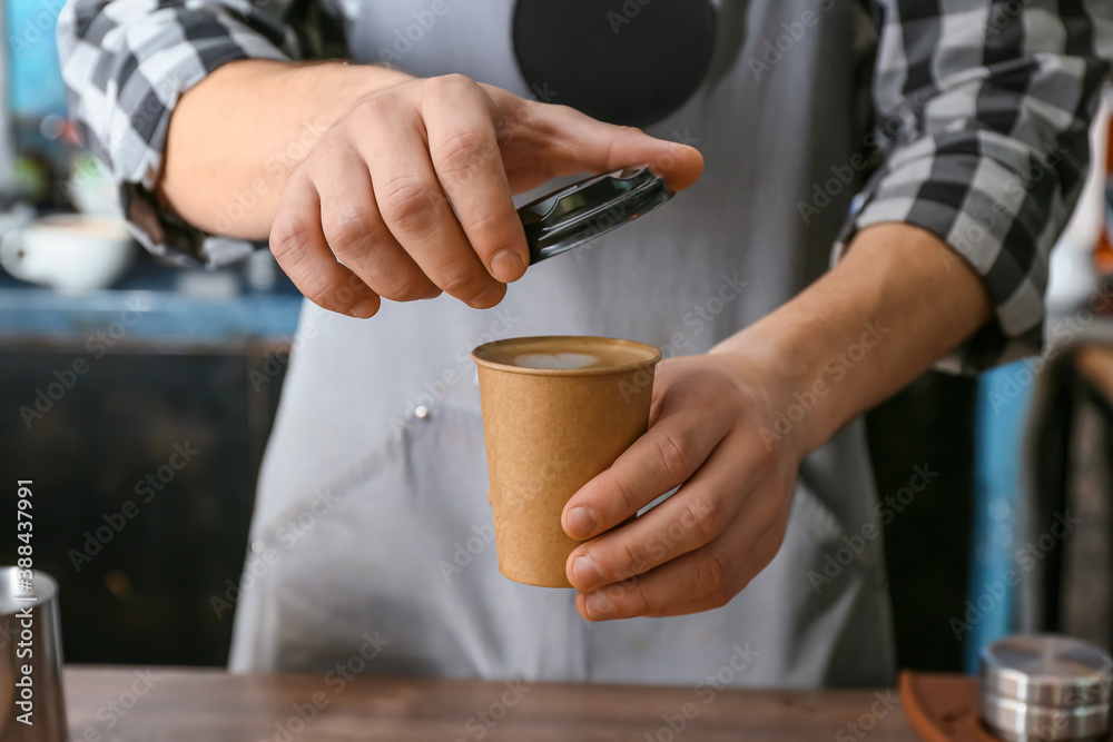 Barista with cup of hot coffee in cafe, closeup